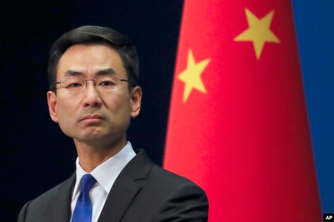 Chinese Foreign Ministry spokesman Geng Shuang listens a question from a reporter during a daily briefing at the Ministry of Foreign Affairs office in Beijing, Wednesday, March 18, 2020.