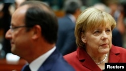 Germany's Chancellor Angela Merkel (R) and France's President Francois Hollande attend a European Union leaders summit in Brussels, Oct. 24, 2013.