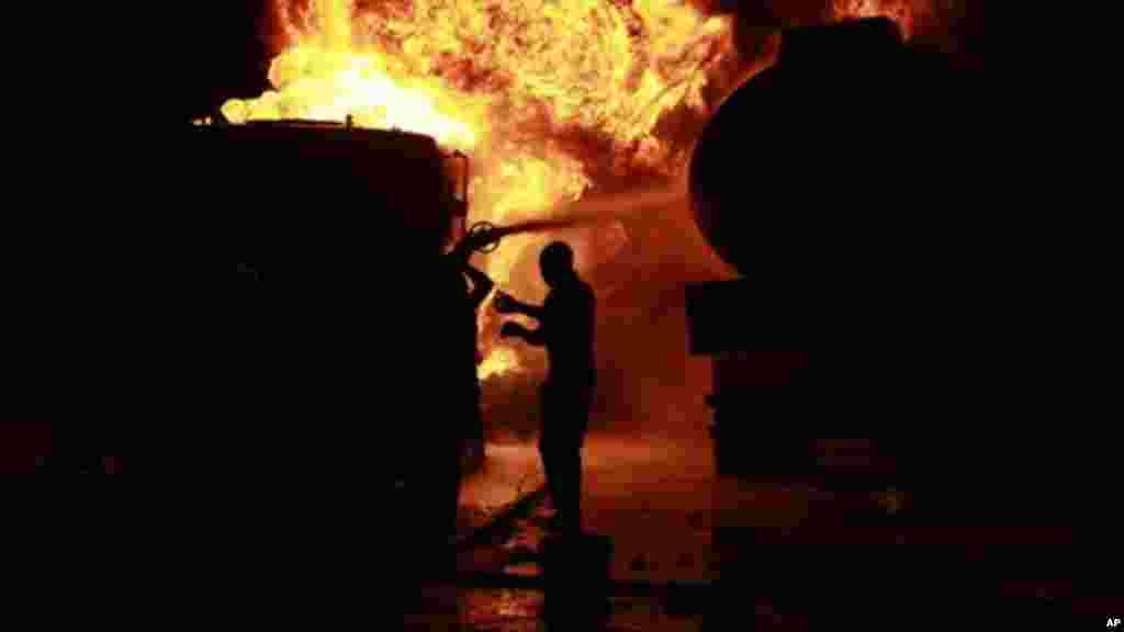 Firefighters try to contain a fire at an informal diesel fuel depot in Lagos, Nigeria on Thursday, Aug. 1, 2013.