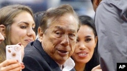 FILE - Los Angeles Clippers owner Donald Sterling, center, and V. Stiviano, right, watch the Clippers play the Sacramento Kings.