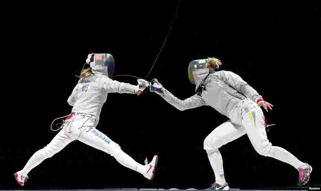 Russia&#39;s Ekaterina Dyachenko (L) competes against Ukraine&#39;s Olga Kharlan during their women&#39;s team saber final at the World Fencing Championships in Moscow.