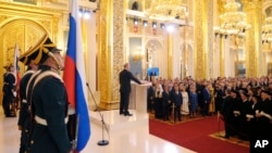 普京在莫斯科克里姆林宫举行的就职典礼上手按宪法第四次宣誓就任俄罗斯总统。（2018年5月7日）