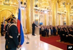普京在莫斯科克里姆林宫举行的就职典礼上手按宪法第四次宣誓就任俄罗斯总统。（2018年5月7日）