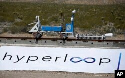 A recovery vehicle moves a sled down a track after a test of a Hyperloop One propulsion system, Wednesday, May 11, 2016, in North Las Vegas, Nev.