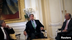 U.S. Secretary of State John Kerry sits between U.S. Secretary of Energy Ernest Moniz (L) and Atomic Energy Agency (IAEA) Director General Yukiya Amano during a meeting at a hotel in Vienna, Austria, June 29, 2015.