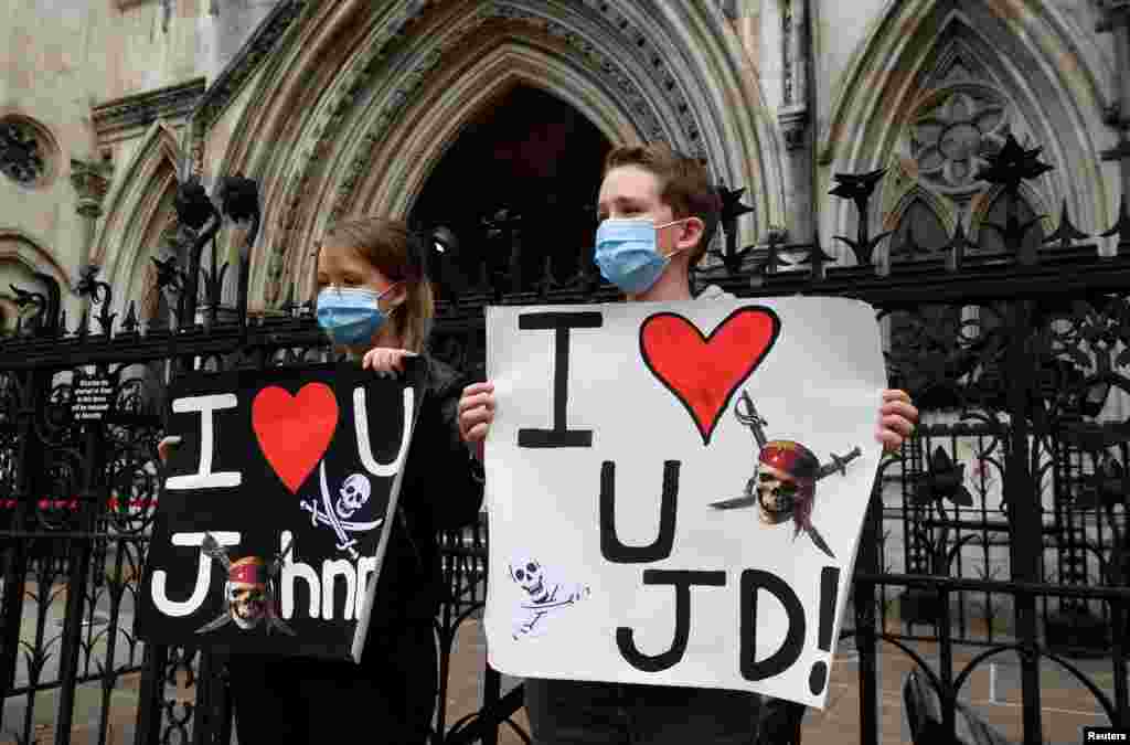 Johnny Depp fans hold signs expressing support for the actor outside Britain&#39;s High Court in London, which is hearing Depp&#39;s libel claim against a British newspaper.