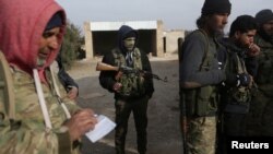 Rebel fighters stand with their weapons on the outskirts of the northern Syrian town of al-Bab, Syria, Feb. 8, 2017. 