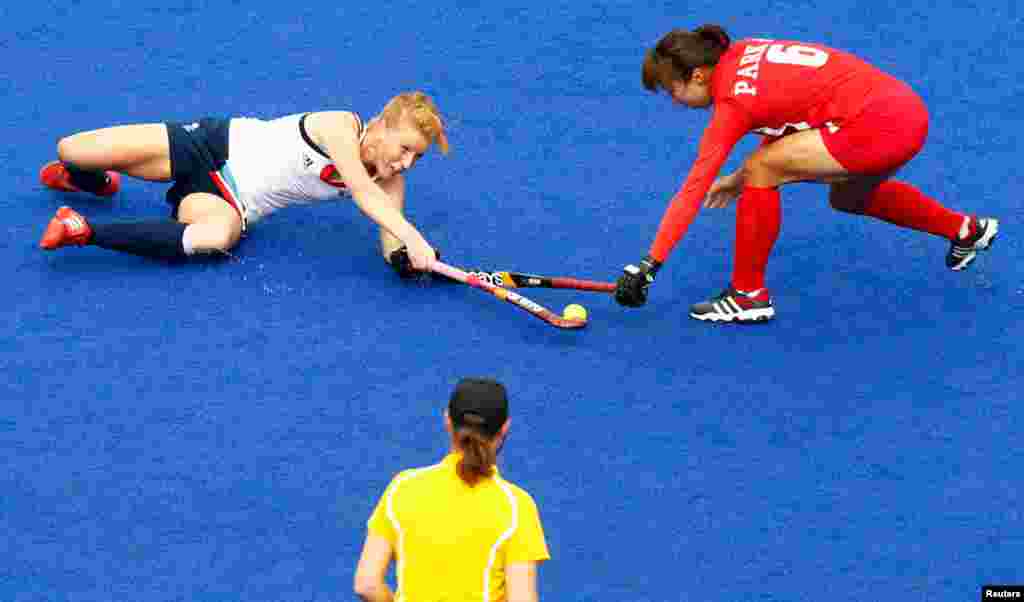 Britain's Nicola White and South Korea's Park Seon-mi fight for the ball during their women's Group A hockey match.