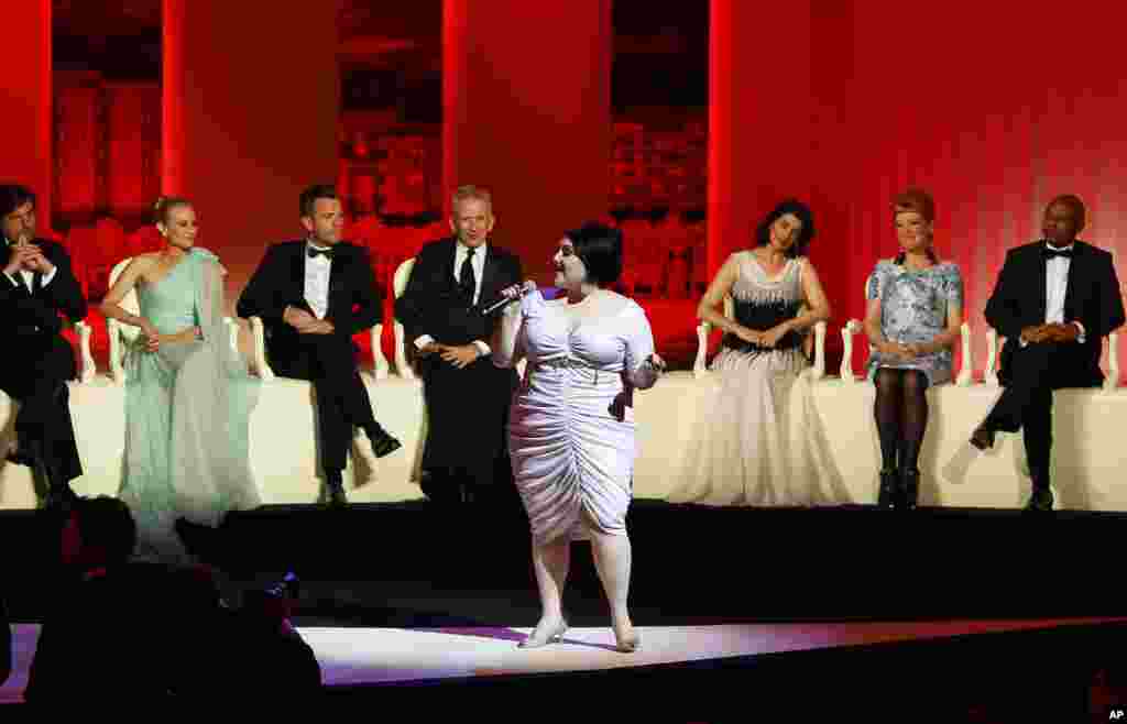 Singer Beth Ditto, at front, performs as members of the jury from left, Nanni Moretti, Diane Kruger, Ewan McGregor, Jean-Paul Gaultier, Hiam Abbass, Andrea Arnold, and Raoul Peck at the opening ceremony at the 65th international film festival, in Cannes, 