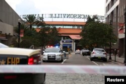 지난 26일 총기사건이 발생한 플로리다 잭슨빌의 "더 잭슨빌 빌딩" 입구를 경찰들이 지키고 있다.