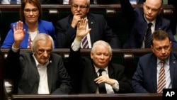 Poland's most powerful politician, ruling Law and Justice Party leader Jaroslaw Kaczynski, center, attends a vote in parliament in Warsaw, Dec. 8, 2017, in which lawmakers approved legislation that gives them control over the Supreme Court. The opposition and the European Union leaders say the legislation threatens the rule of law.