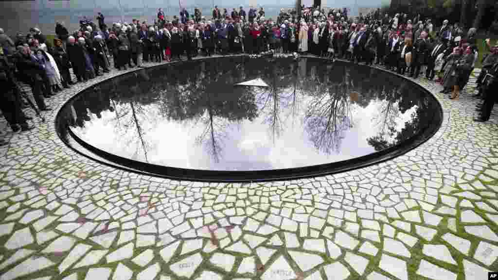 People attend the inauguration ceremony at the memorial to the murdered European Sinti and Roma who were persecuted as 'Gypsies' in Berlin, October 24, 2012.