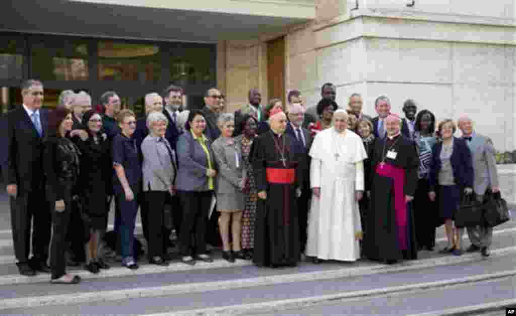 Pape François pose pour une photo avec les membres du laïcat à son arrivée pour une session d&rsquo;après-midi au synode de deux semaines sur les questions de la famille, au Vatican, le vendredi 10 octobre 2014. Les défenseurs des droits des gays applaudissent prudemment applaudir un probable changement de ton de la Église catholique.(AP Photo/Andrew Medichini) 