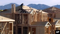 FILE - A worker prepares the roof of a new home for solar paneling in San Diego.