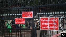 Prison officers and police gather near the entrance of Insein Prison in Yangon, Myanmar, Oct. 18, 2021, ahead of an announced amnesty.