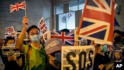 In this Oct. 23, 2019, file photo, demonstrators wave British flags during a rally outside the British Consulate in Hong Kong. (AP Photo/Mark Schiefelbein, File)