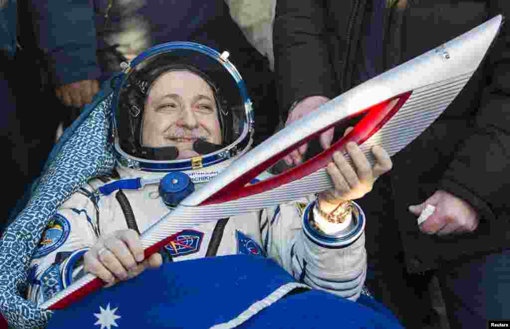 Russian cosmonaut Fyodor Yurchikhin holds the torch of the 2014 Sochi Winter Olympic Games after landing near the town of Zhezkazgan in central Kazakhstan.