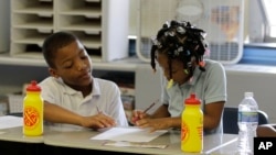 Antonio Robinson, left, and Romae Robinson work together in a fan cooled classroom at Theodore Potter School 74 in Indianapolis, Thursday, Aug. 12, 2010. (AP Photo/Michael Conroy)