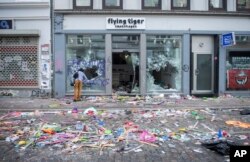 A man looks through the broken window of a shop in Hamburg, Germany, July 8, 2017. Anti-globalization activists rioted for a second night as Hamburg hosted the Group of 20 leaders.