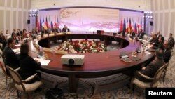 Participants sit at a table during talks on Iran's nuclear program in Almaty, February 26, 2013.