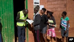 Zimbabuenses hacen fila para votar en las elecciones en una escuela primaria en Kwekwe, Zimbabue, el lunes, 30 de julio de 2018.