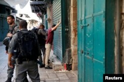 Israeli border policemen search a Palestinian man in Jerusalem's Old City, July 14, 2017.