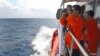 A member of Indonesian National Search and Rescue Agency (BASARNAS) uses a binocular to scan the horizon during a search operation for the missing Malaysia Airlines Boeing 777 conducted on the waters of the Strait of Malacca off Sumatra island, Indonesia,