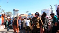 People gather in the main square of Herat city in western Afghanistan, where the Taliban hanged a dead body from a crane, on Sept. 25, 2021.