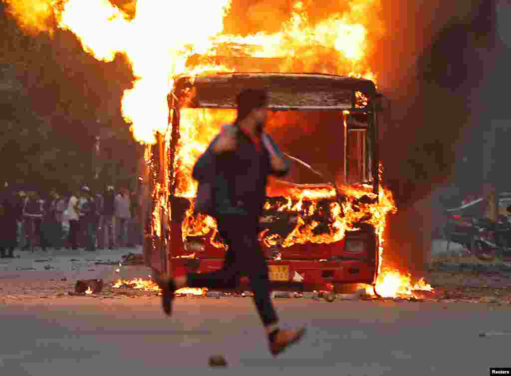 متنازع شہریت قانون کے خلاف دارالحکومت نئی دہلی سمیت مختلف شہروں میں احتجاج کیا جا رہا ہے۔سڑکوں پر جلاؤ گھیراؤ کے بعد حساس علاقوں میں پولیس کا گشت بڑھا دیا گیا ہے۔ دہلی میں چلنے والی کئی سرکاری بسوں کو نذر آتش کیا جا چکا ہے۔ تصویر میں ایک شخص آگ کے شعلوں میں لپٹی بس کے قریب سے گزر رہا ہے۔&nbsp; &nbsp;