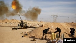 FILE - Libya Dawn fighters fire an artillery cannon at Islamic State militants near Sirte, March 19, 2015.