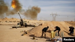 FILE - Libya Dawn fighters fire an artillery cannon at Islamic State militants near Sirte, March 19, 2015.