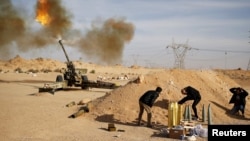 FILE - Libya Dawn fighters fire an artillery cannon at Islamic State militants near Sirte, March 19, 2015.