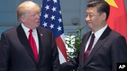 FILE - U.S. President Donald Trump, left, and Chinese President Xi Jinping arrive for a meeting on the sidelines of the G-20 Summit in Hamburg, Germany.