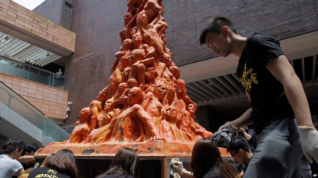 Estudianes universitarios limpian la estatua "Pilar de la VergÃ¼enza" en recuerdo de los muertos en la represiÃ³n de Tiananmen hace 29 aÃ±os, en la Universidad de Hong Kong el lunes, 4 de junio de 2018.