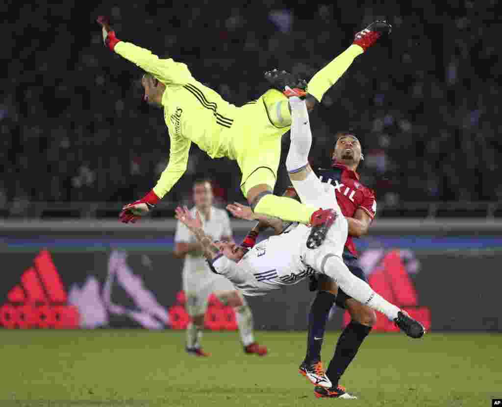 Kashima Antlers' Fabricio, right, collides with Real Madrid's Sergio Ramos, bottom, and goalkeeper Keylor Navas for a ball battle during their final match at the FIFA Club World Cup soccer tournament in Yokohama, near Tokyo, Dec. 18, 2016.