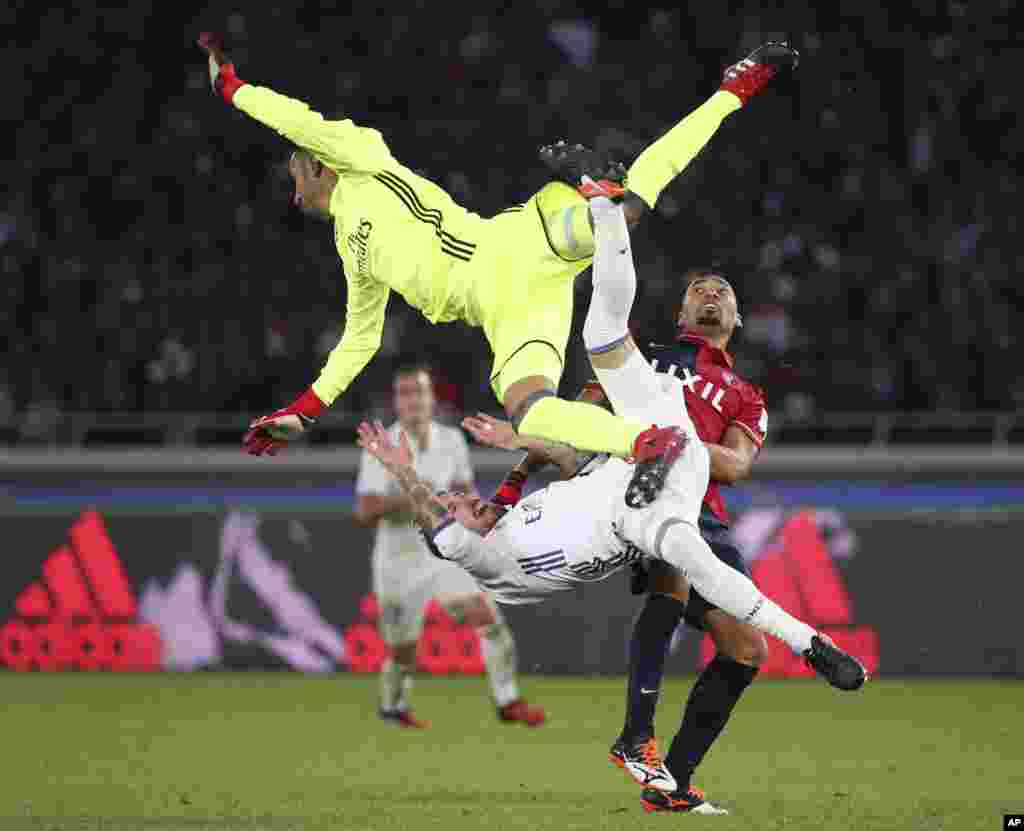 កីឡាករ Fabricio របស់ក្រុម Kashima Antlers (រូបស្តាំ) ប៉ះទង្គិចជាមួយនឹងកីឡាករ Sergio Ramos របស់ក្រុម Real Madrid (រូបខាងក្រោម) និងអ្នកចាំទី Keylor Navas ក្នុងការប្រកួតបាល់ទាត់វគ្គផ្តាច់ព្រ័ត្រសម្រាប់ពានរង្វាន់ FIFA Club World Cup នៅក្នុងក្រុង Yokohama ប្រទេសជប៉ុន។