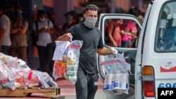 A worker loads online purchases on a van to be delivered, outside a pick up center in Havana, Cuba, on June 17, 2020. (Photo by YAMIL LAGE / AFP)