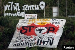 FILE - A protest banner demanding a stop to rapids blasting at the Mekong River is seen at the border between Laos and Thailand, April 24, 2017.