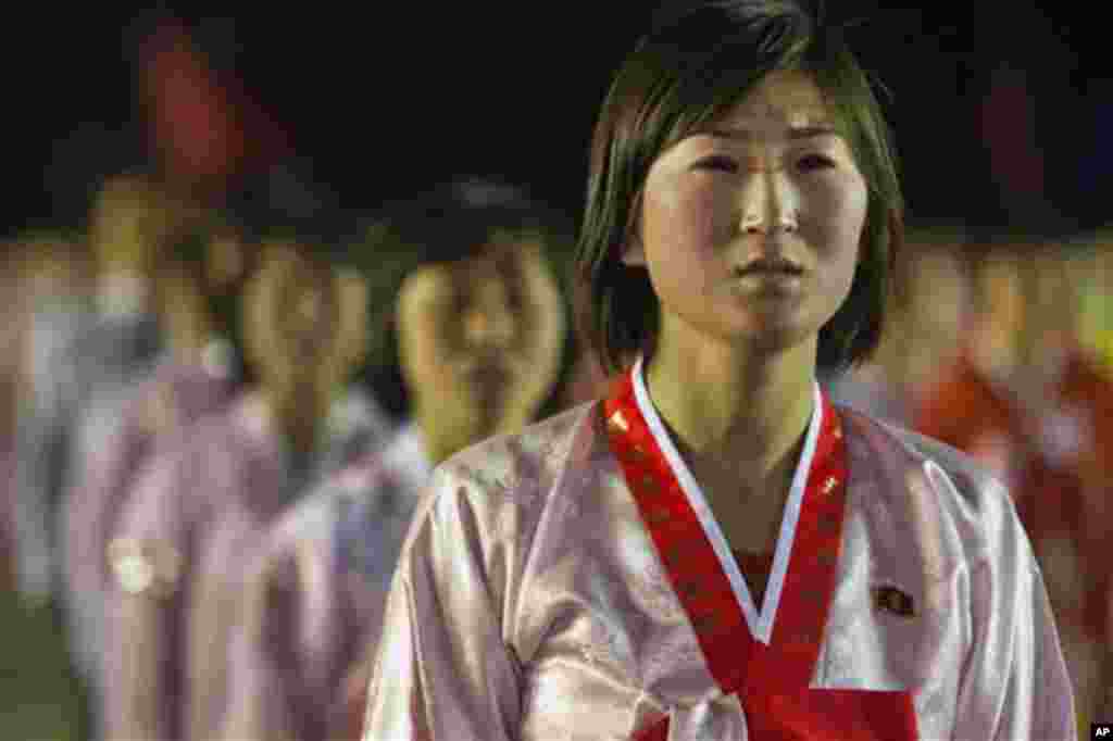 A North Korean woman weeps and sings a song about North Korean leader Kim Jong Un at the end of a mass dance performance in Kim Il Sung Square in Pyongyang, North Korea, Monday April 16, 2012. (AP Photo/David Guttenfelder)