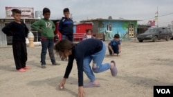 Children play in the dirt road of a Domiz, Iraq, refugee camp (VOA).