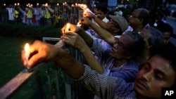 Indian people put candles onto fence as they protest killing of Avijit Roy, a prominent Bangladeshi-American blogger, in Kolkata, India, March 1, 2015.