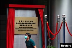 一名男子走过香港一家酒店外北京新设的驻港国安公署的牌子。（2020年7月8日）