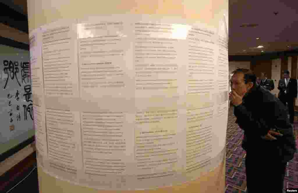 A relative of a passenger onboard the missing Malaysia Airlines Flight MH370 reads a statement from Malaysia Airlines at a hotel in Beijing, March 18, 2014.
