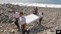 지난 29일 프랑스 경찰들이 레위니옹섬에서 발견된 항공기 잔해를 운반하고 있다. 