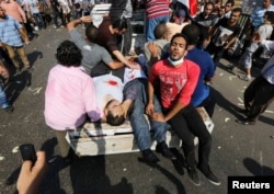 Protesters, who support ousted Egyptian President Mohamed Morsi, transport injured people during clashes at Ramses Square in Cairo, Aug. 16, 2013