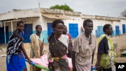 Women carry the body of a civilian killed in the center of Malakal, Upper Nile State in South Sudan, Jan. 21, 2014.