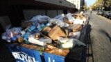 FILE - A dumpster filled with spoiled food waits for removal behind a Key Food supermarket in the still powerless East Village section of Manhattan, November 01, 2012, in New York.
