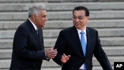 Sri Lanka's Prime Minister Ranil Wickremesinghe, (l) chats with Chinese Premier Li Keqiang during a welcome ceremony outside the Great Hall of the People in Beijing, April 7, 2016.
