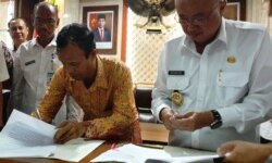 Pendeta Sitorus dan Suharsono menandatangani kesepatan di luar pengadilan terkait ijin bagi GPdI Immanuel di Kabupaten Bantul, DIY. (Foto:VOA/ Nurhadi)