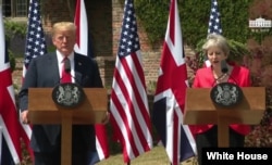 FILE - Britain's Prime Minister Theresa May and U.S. President Donald Trump hold a joint news conference at Chequers, the official country residence of the prime minister, in Buckinghamshire, England, July 13, 2018.
